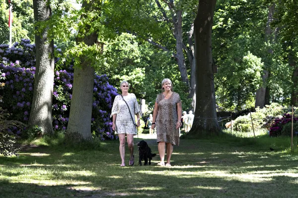 To personer gaar tur med en hund.