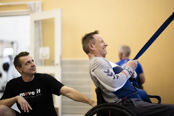 En medarbejder hjaelper patient med at traene i traeningscentret i Roedovre.