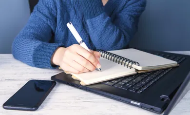 En person sidder og tager referat.