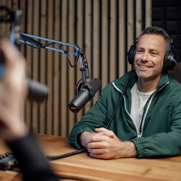 En person sidder og bliver interviewet til en podcast.